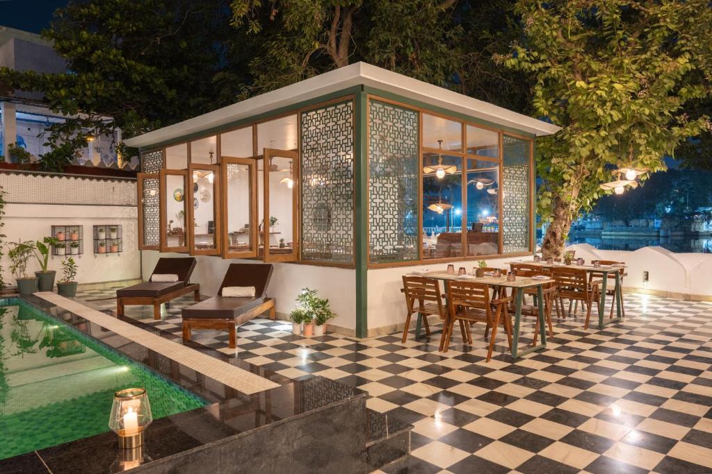 a pavilion with tables and chairs on a checkered floor at The Experience Resort-Lake Facing in Udaipur