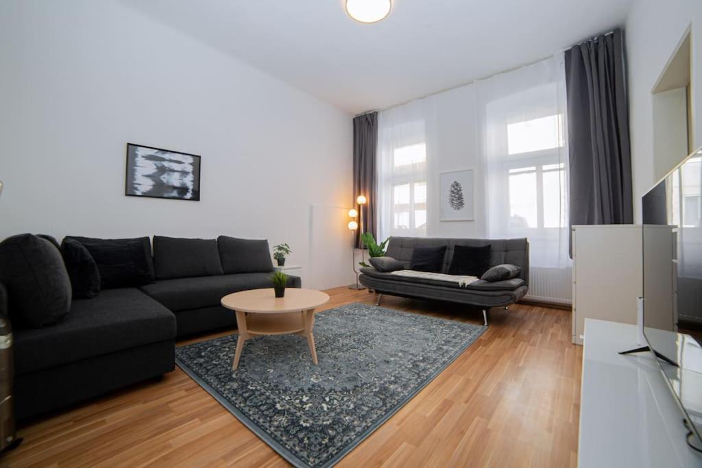 sala de estar con sofá negro y mesa en Modern Apartment near City Center 1BR en Viena