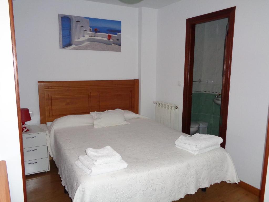 1 dormitorio con 1 cama con toallas en Apartamentos San Pelayo, en Cangas de Onís