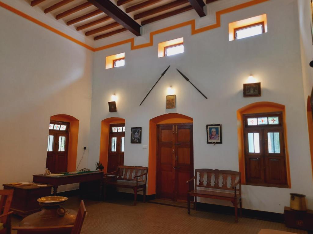 een kamer met een tafel en stoelen in een gebouw bij Heritage Home, Hampe's in Mysore
