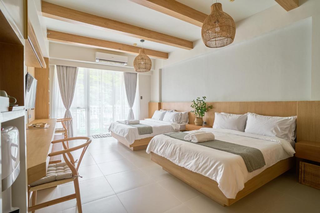 sypialnia z 2 łóżkami i oknem w obiekcie Yugen Suites 208 at Pico De Loro w mieście Nasugbu