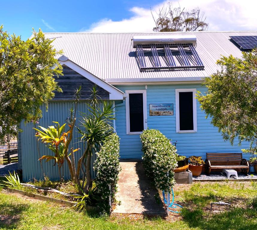 a blue house with a bench in front of it at Nambucca Lodge in Nambucca Heads