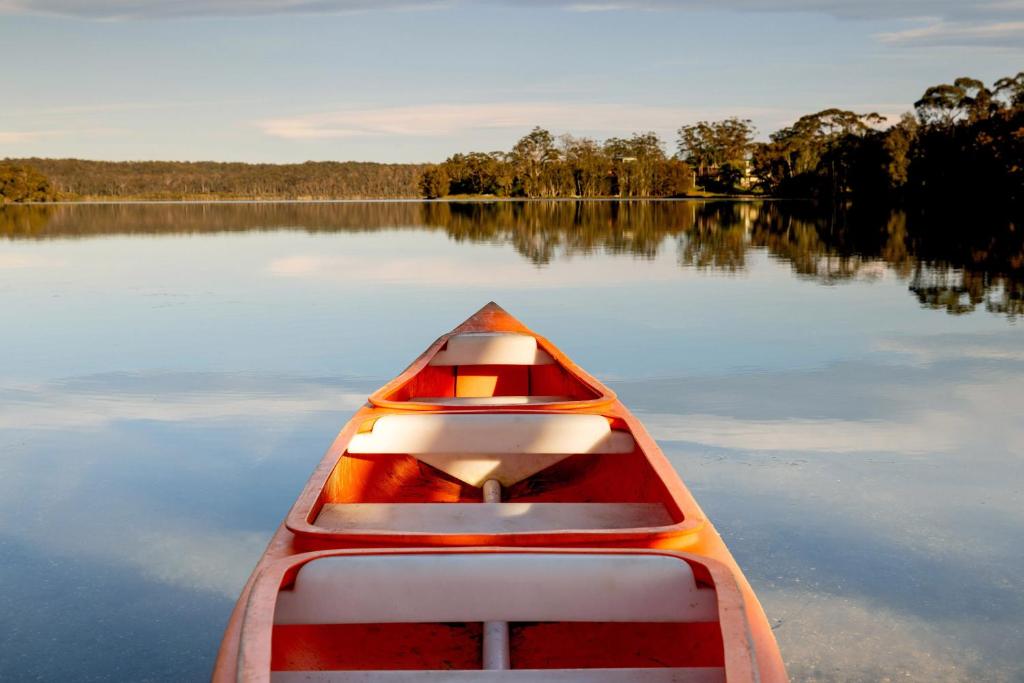 a red and white boat on a lake at BIG4 Wallaga Lake Holiday Park in Bermagui