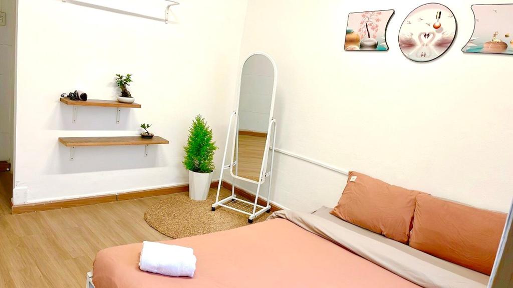 um quarto com um espelho, uma cama e uma cadeira em Abahi homestay số 3a em Xuan An