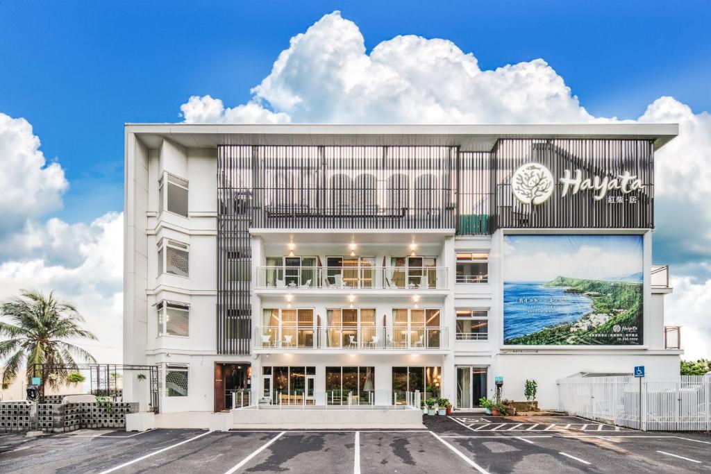 a white building with a large sign on it at Hayata Hotel in Hengchun