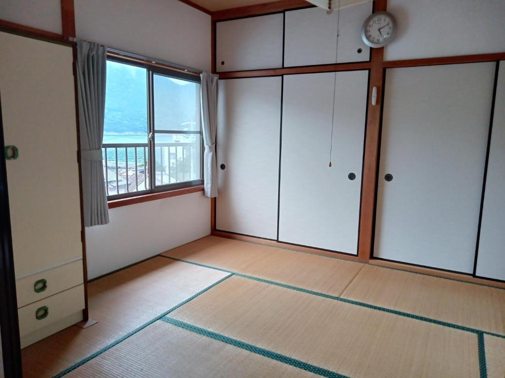 una stanza vuota con un orologio sul muro di Bayside House Shiosai - Vacation STAY 15343 a Kumano