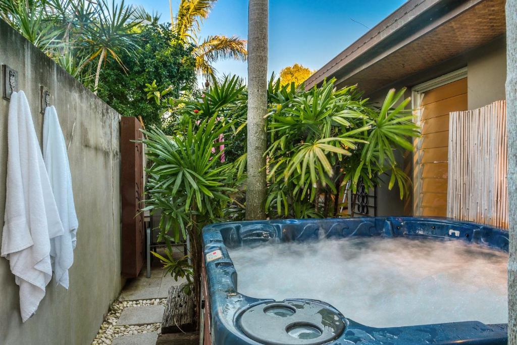 a hot tub in a backyard with palm trees at A Perfect Stay - Brandon St Beach and Spa in Suffolk Park