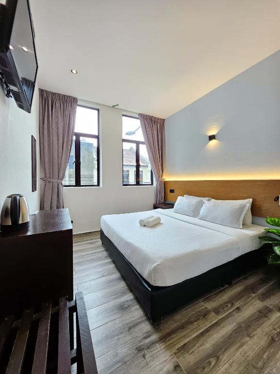 una camera da letto con un letto grande e una TV a schermo piatto di Georgetown Inn by Sky Hive a George Town