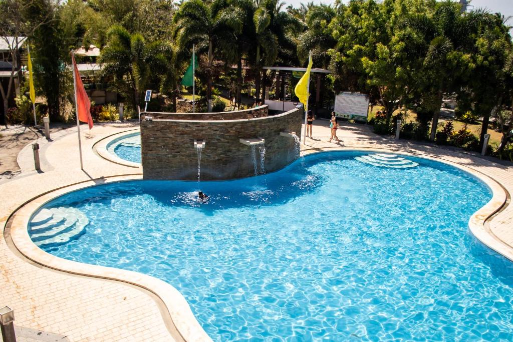 una gran piscina con una fuente de agua en PATIO BUENDIA FARM RESORT AND EVENTS PLACE en Amadeo