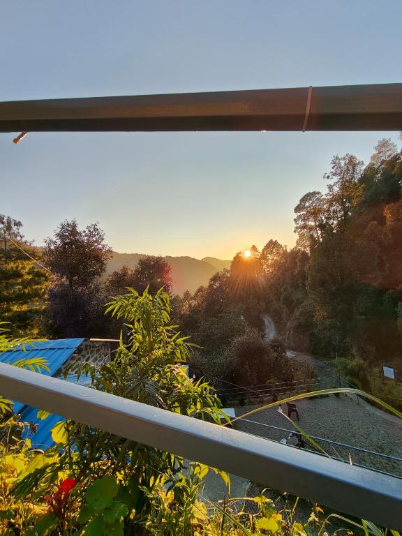 奈尼塔尔HimWanderer Camps & Cottages Pangot的从日落的窗口欣赏美景