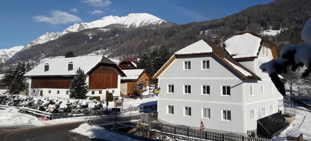 um grande edifício branco com neve no telhado em Apartment Schlickenhof em Hintergöriach