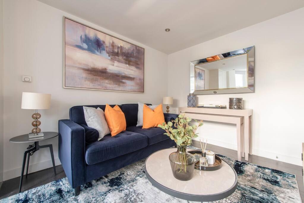 a living room with a blue couch and a table at Elevated Elegance: 1BR 1BA Flat in Wellmeadow Rd in London
