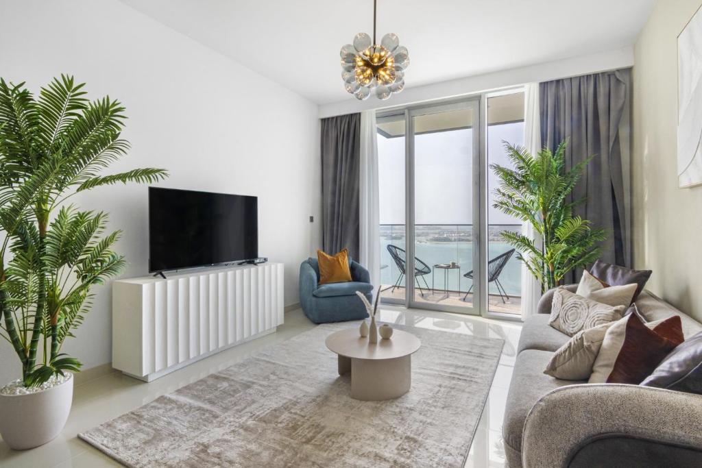 een woonkamer met een bank en een tv bij Sea view 2-Bedroom - Beach Isle in Dubai