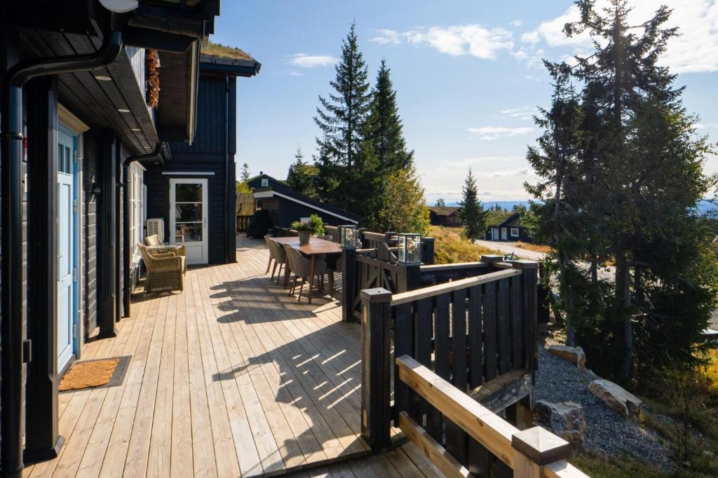 a deck with a table and chairs on a house at Løvsangeren 1,5 hour from Oslo - 6 bedrooms - 14 sleeps - Sauna in Nordset
