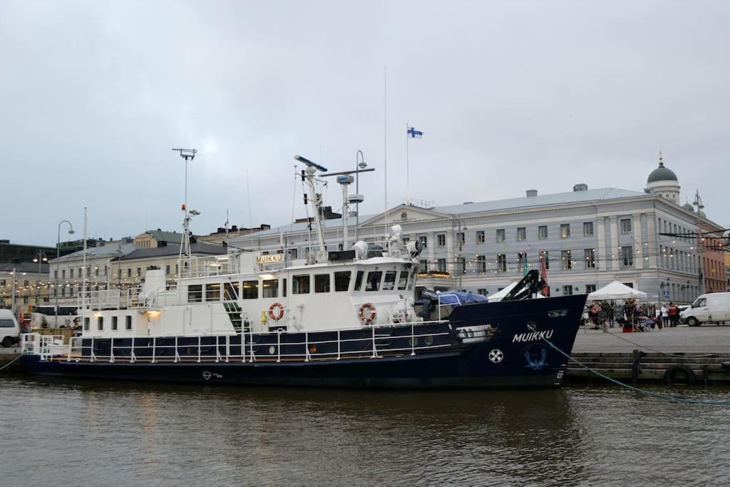 ヘルシンキにあるHotellilaiva Muikku/Hotel Boat Muikkuの船が建物の隣の水中に停泊している