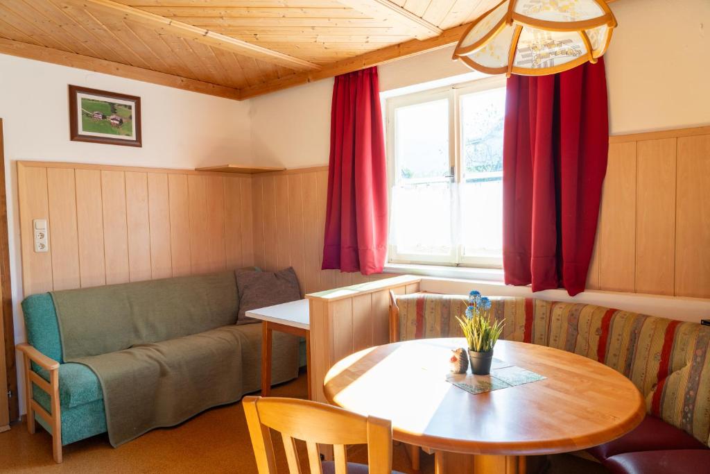 sala de estar con mesa y sofá en Knollgut Ferienwohnung Buchberg, en Goldegg