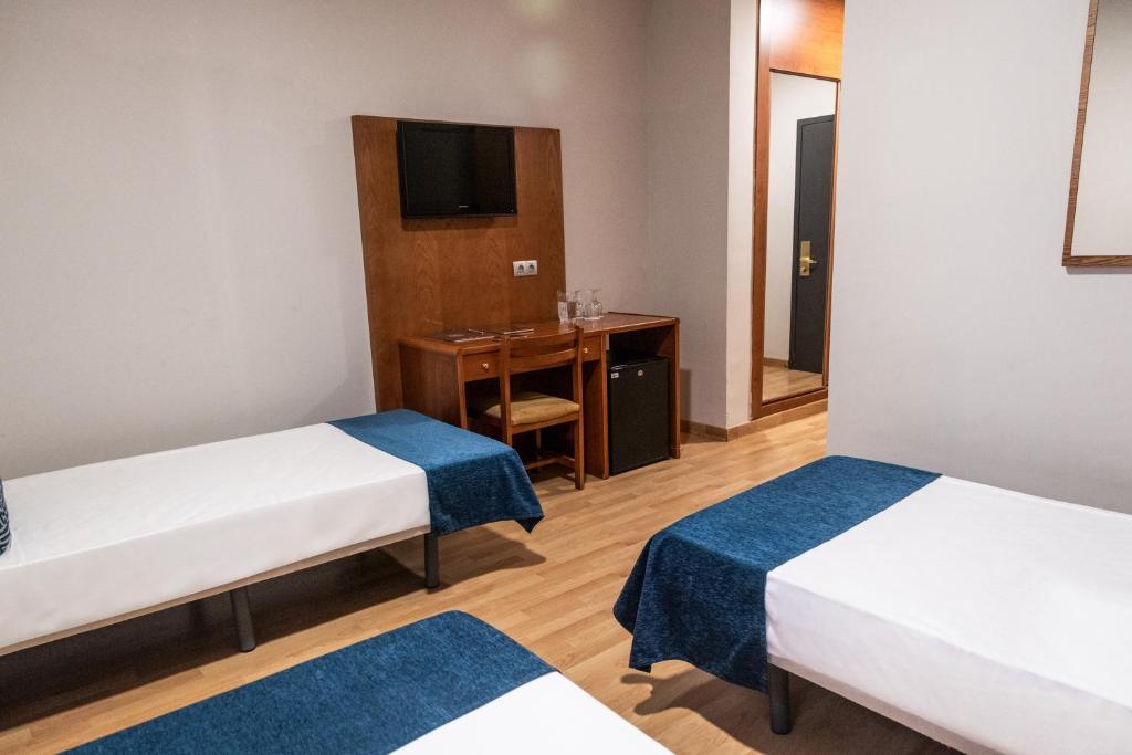 a hotel room with two beds and a desk at Hotel Adonis Plaza in Santa Cruz de Tenerife