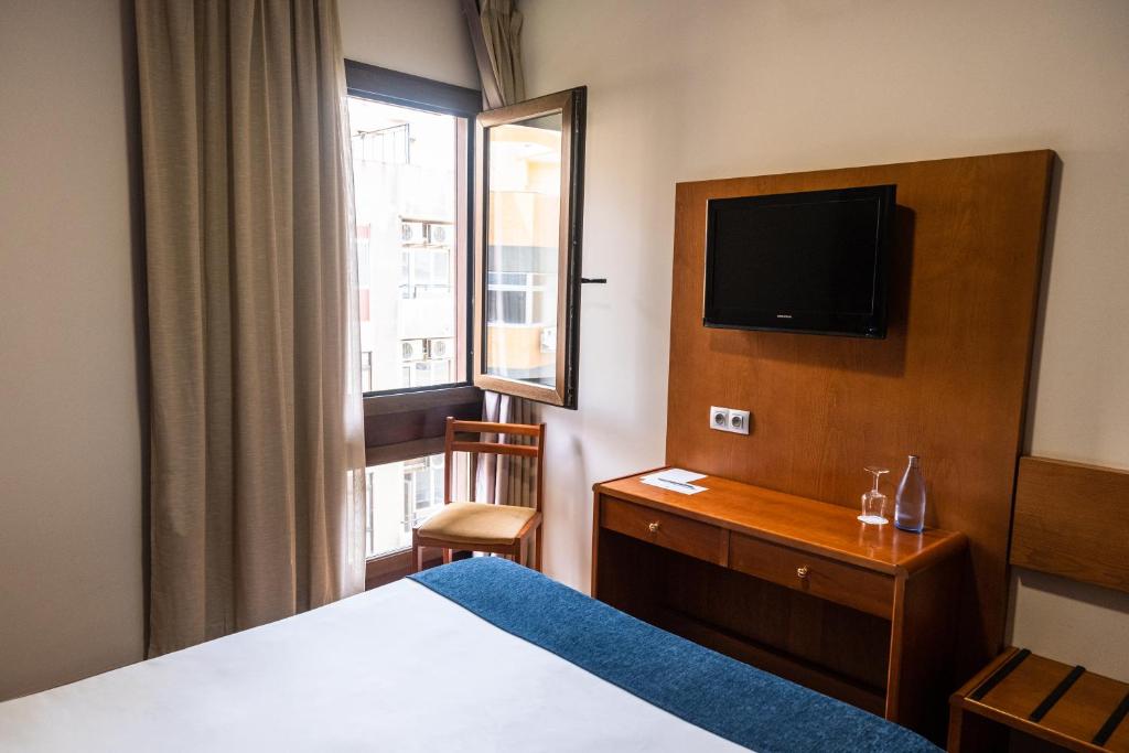 a hotel room with a bed and a television at Hotel Adonis Plaza in Santa Cruz de Tenerife