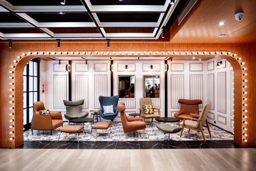 un vestíbulo con un montón de sillas y mesas en Voyager Hotel, en Tainan