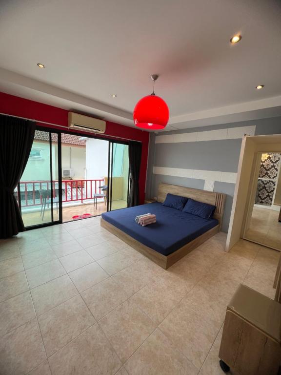 a bedroom with a blue bed and a red lamp at Petunya Phuket Guest House in Ban Huai Luk (1)