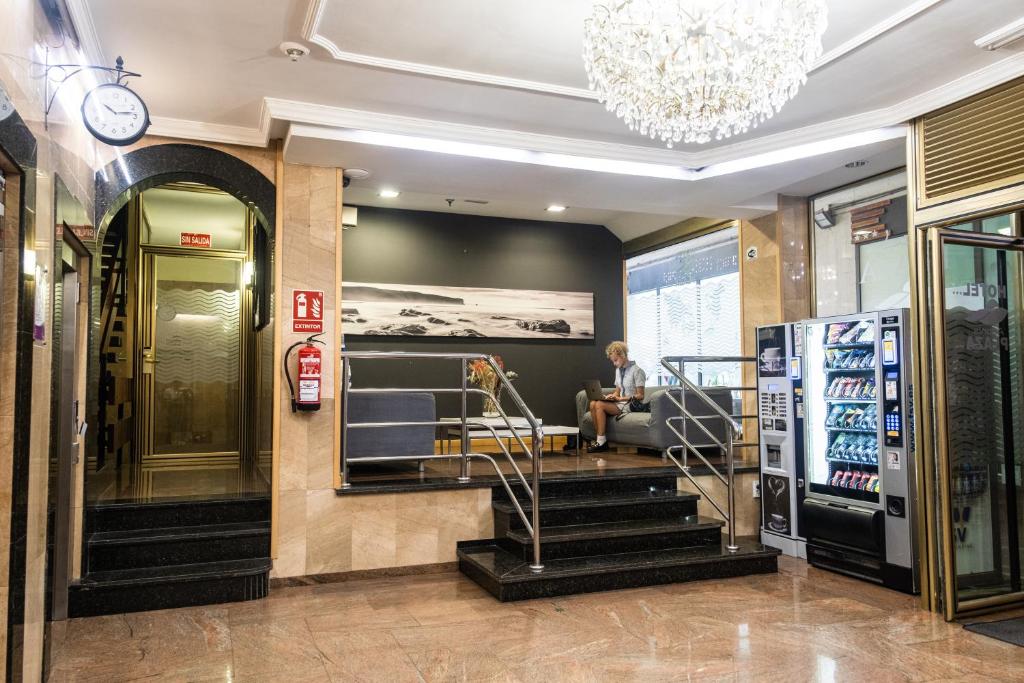 a man sitting on a couch in the lobby of a store at Hotel Adonis Plaza in Santa Cruz de Tenerife