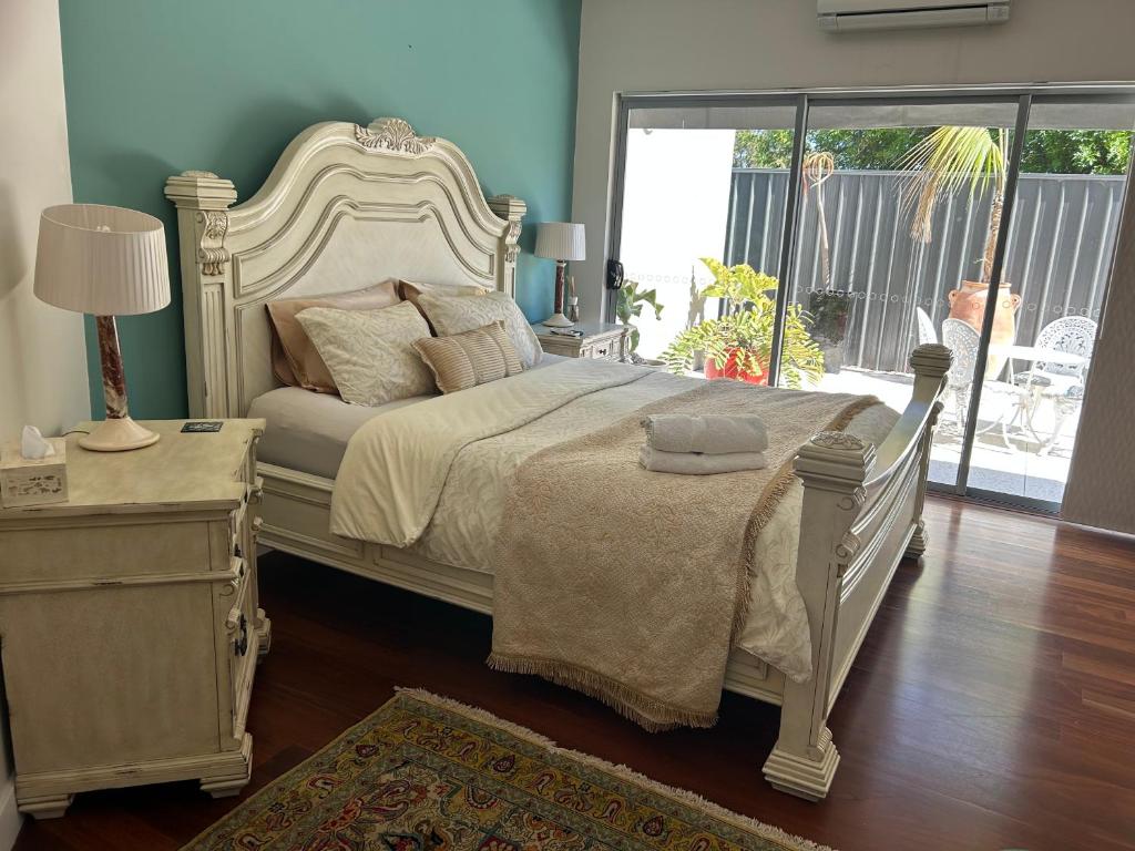 - une chambre avec un lit blanc et une fenêtre dans l'établissement Koombana Retreat, à Perth