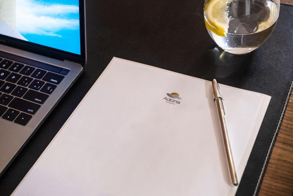 a pen sitting on top of a notebook next to a laptop at Hotel Adonis Plaza in Santa Cruz de Tenerife
