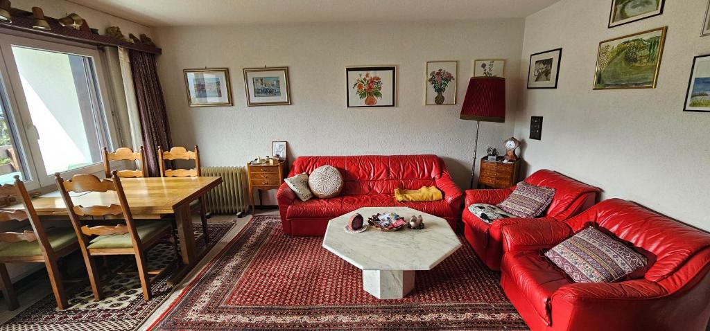 sala de estar con sofá rojo y mesa en Waldrand Haus B 4. Stock, en Bellwald