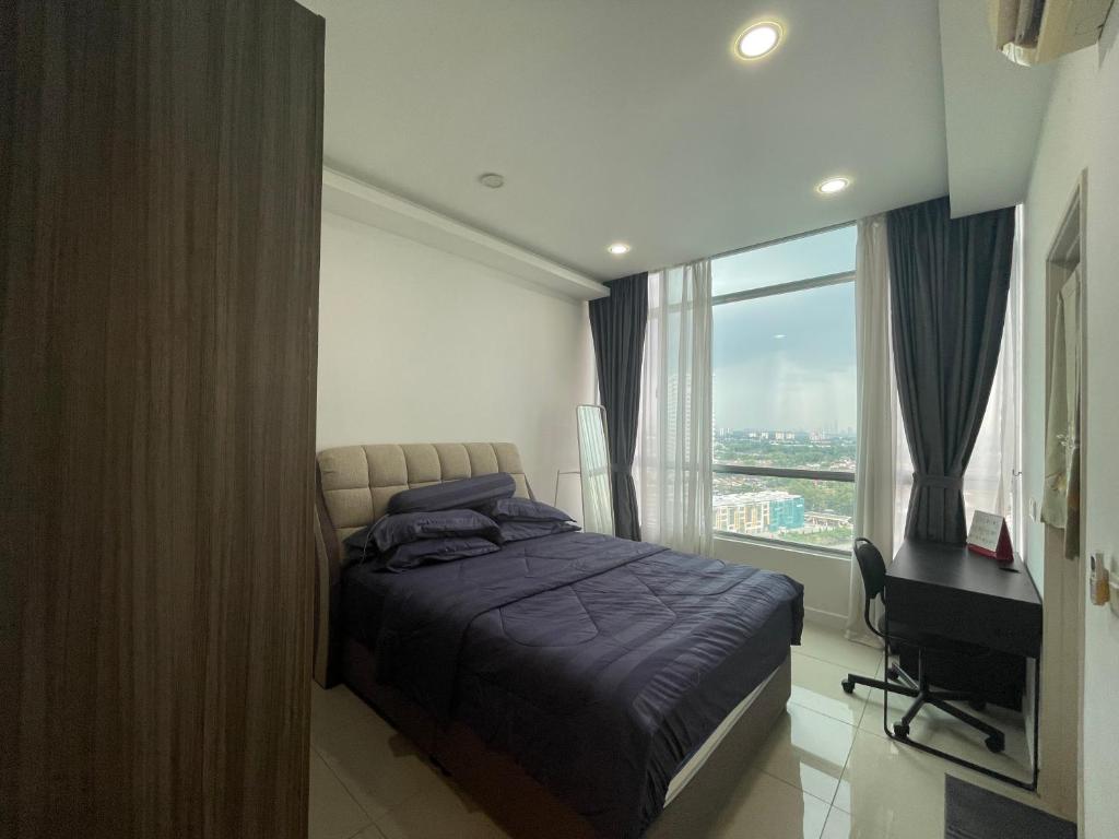 a bedroom with a bed and a desk and a window at Comfy Stay by SE in Johor Bahru