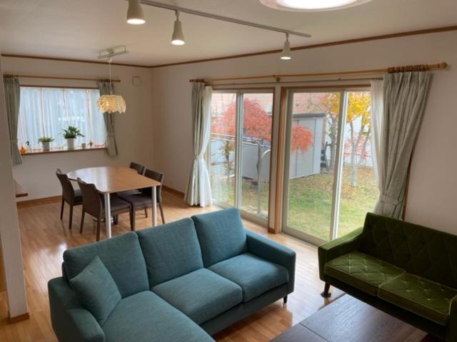 富士河口湖的住宿－GuestHouse　YOU&I，客厅配有蓝色的沙发和桌子