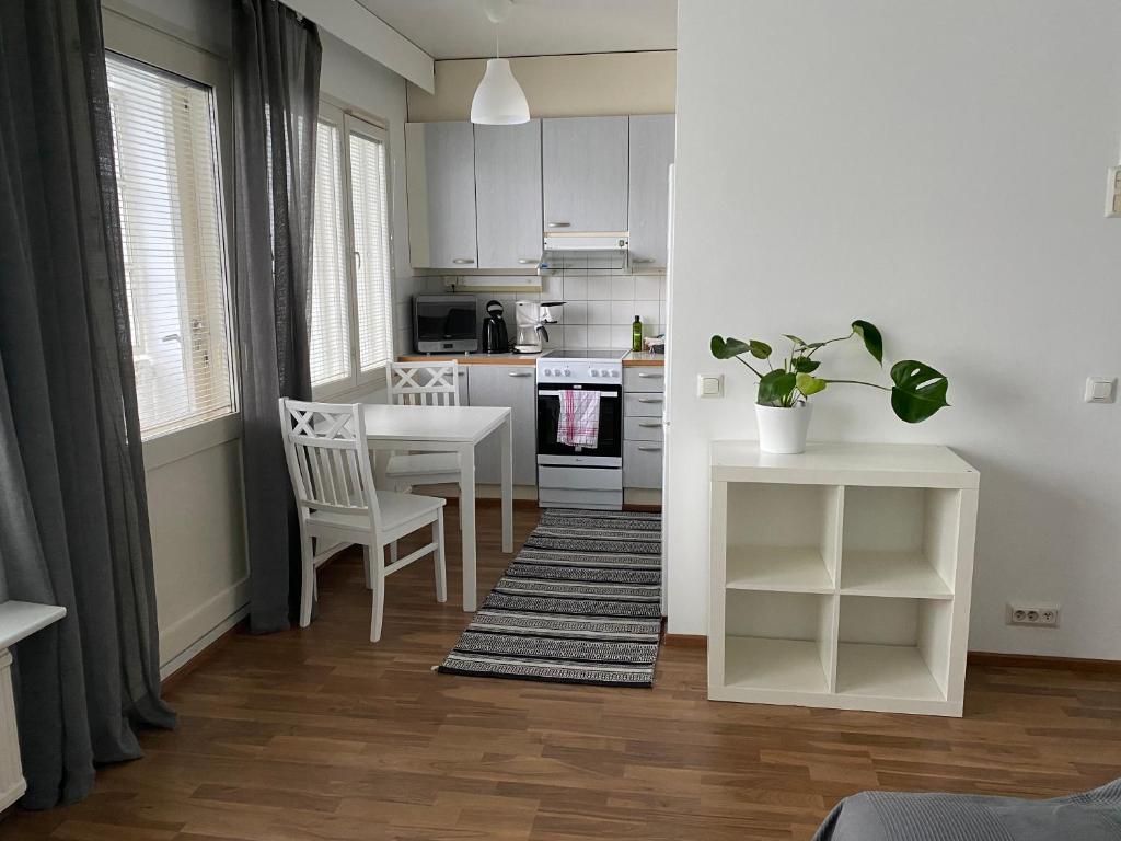 een keuken met witte kasten en een tafel en stoelen bij Tilava yksiö Niinivaaralla in Joensuu