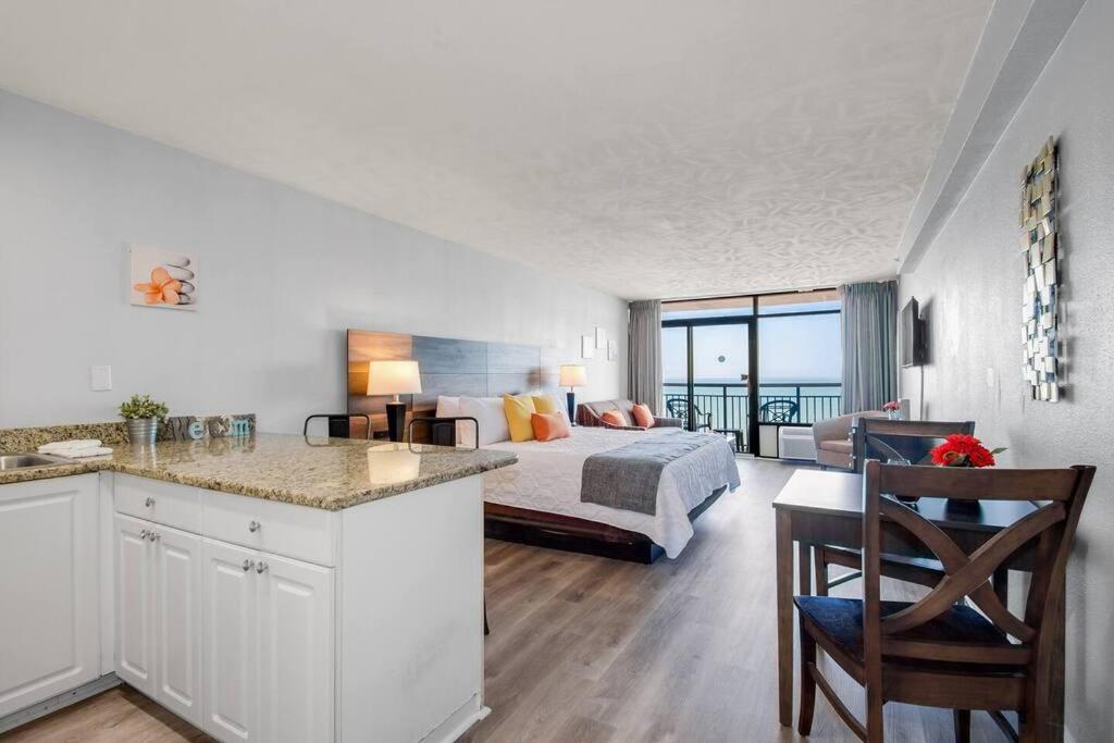 Habitación de hotel con 1 cama y 1 dormitorio con vistas. en Spacious King Oceanfront Studio Suite Full Kitchen 1026, en Myrtle Beach