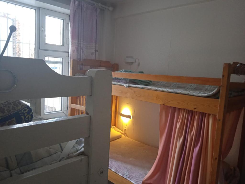 a room with two bunk beds and a window at Bolod Guesthouse and Tours in Ulaanbaatar