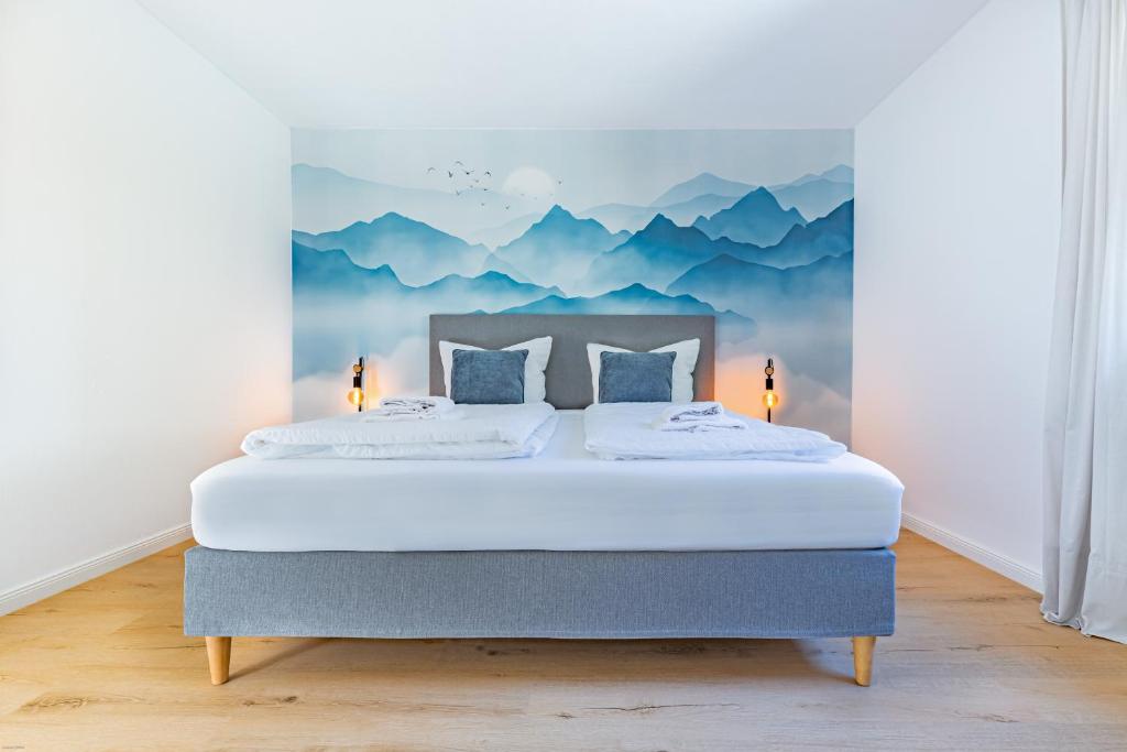 a bedroom with a bed with a mountain mural on the wall at AUSZEIT am ALPSEE - Wohlfühloase auf 69 m2 in Immenstadt im Allgäu