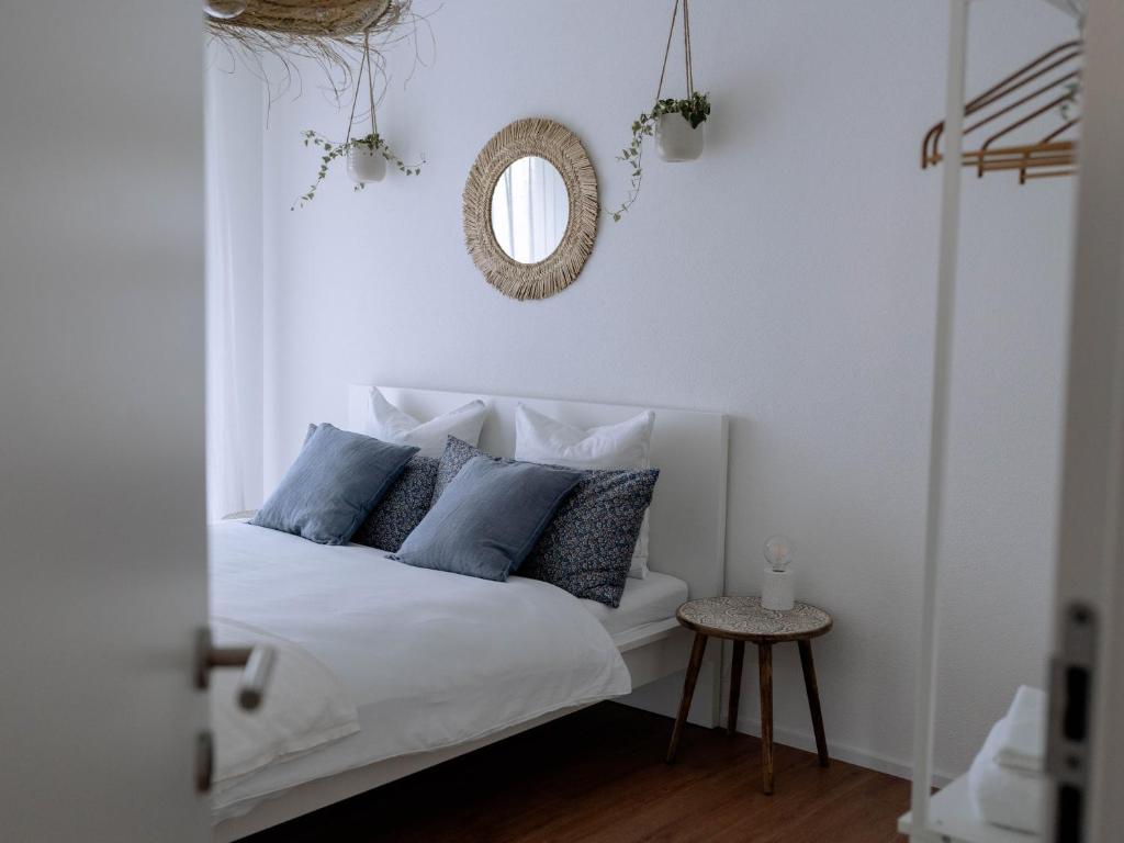 um quarto com uma cama com almofadas azuis e um espelho em Chez-Marie Vue fantastique entre lac et montagne em Beckenried