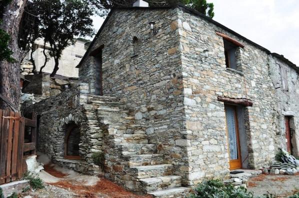 an old stone building with stairs on the side of it at CABANON TIMANTHE in Canari
