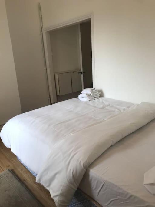 a large white bed in a white room at Lovely 1 bed flat in great location with garden in Ilford
