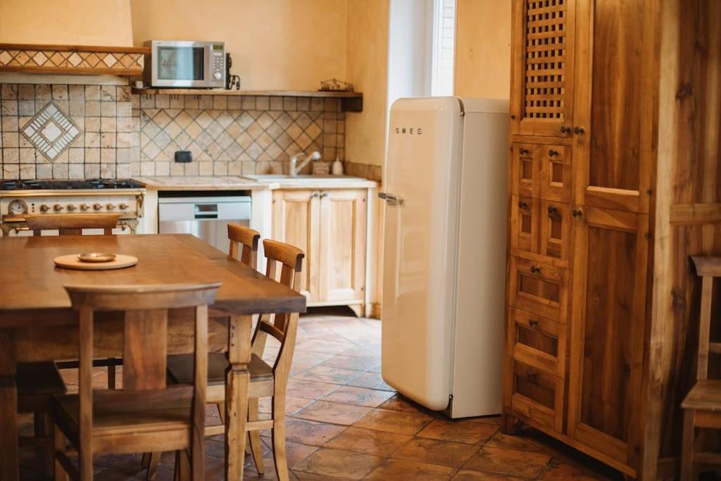 a kitchen with a table and a white refrigerator at Maison Fumin by Hili in Aosta