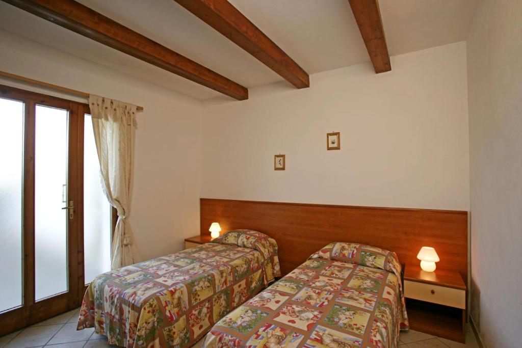 a hotel room with two beds and a window at Agriturismo Parmoleto in Montenero