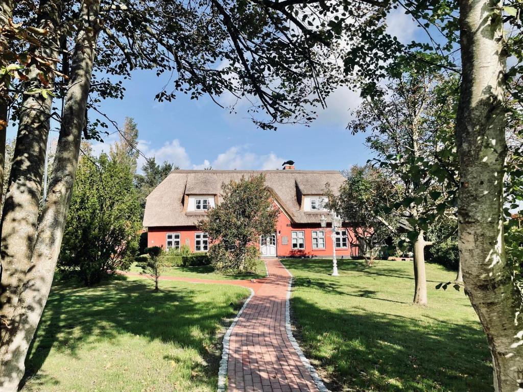 a brick path leading to a red house at Alte Schule SPO in Sankt Peter-Ording