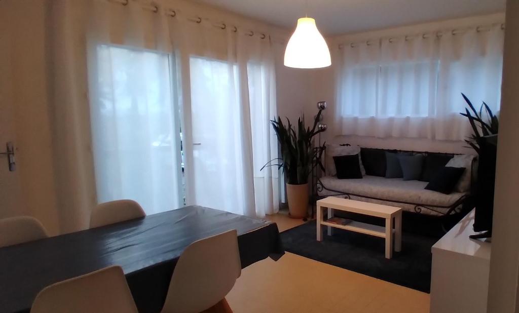 ein Wohnzimmer mit einem Tisch und einem Sofa in der Unterkunft La Bernaudine in Annonay