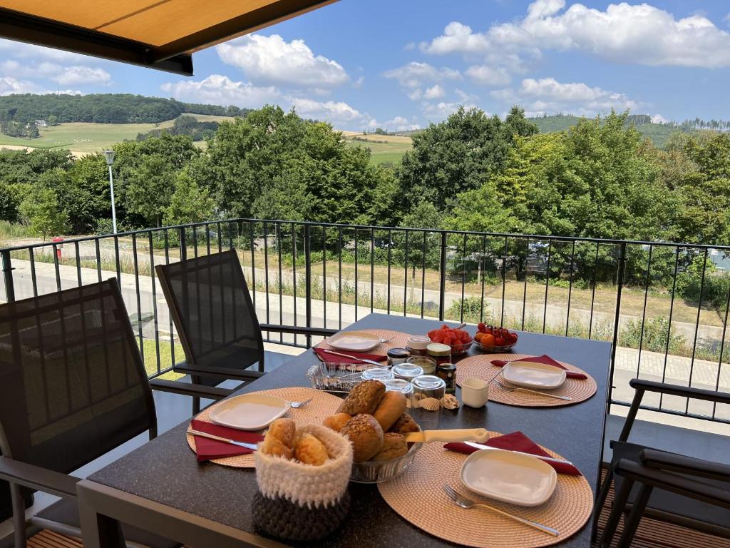 Diemelsee的住宿－Ferienhaus Catharina，阳台上的餐桌上摆放着食物