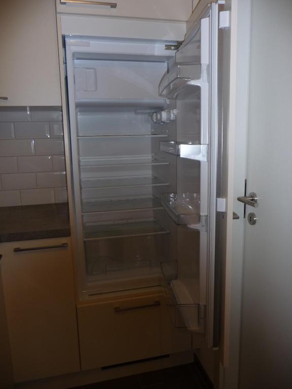 Un refrigerador vacío con la puerta abierta en una cocina. en C&C Eco Studio, en La Sonnaz
