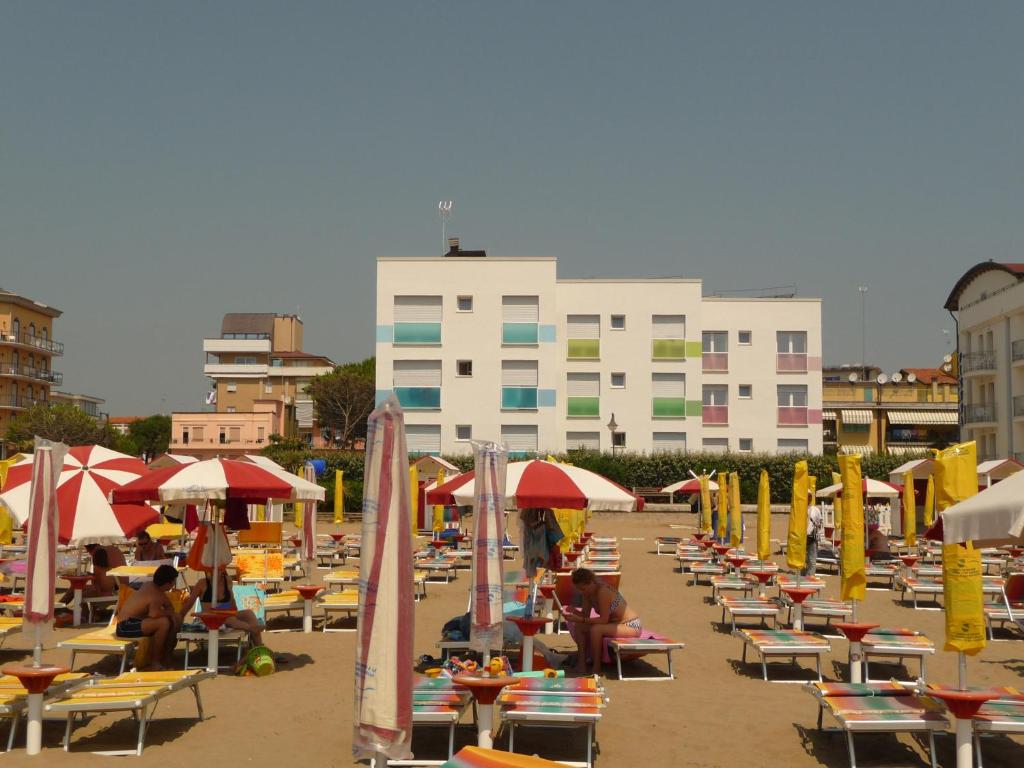 een strand met veel stoelen en parasols en een gebouw bij Soggiorno Aurora in Caorle