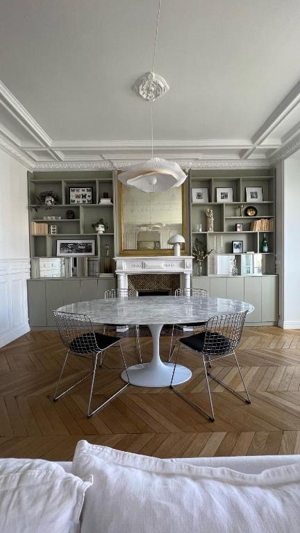 une cuisine avec une table et des chaises dans une pièce dans l'établissement Grand appartement Haussmannien à 12 min de Paris - chic spacious classic Parisian apartment, à Enghien-les-Bains