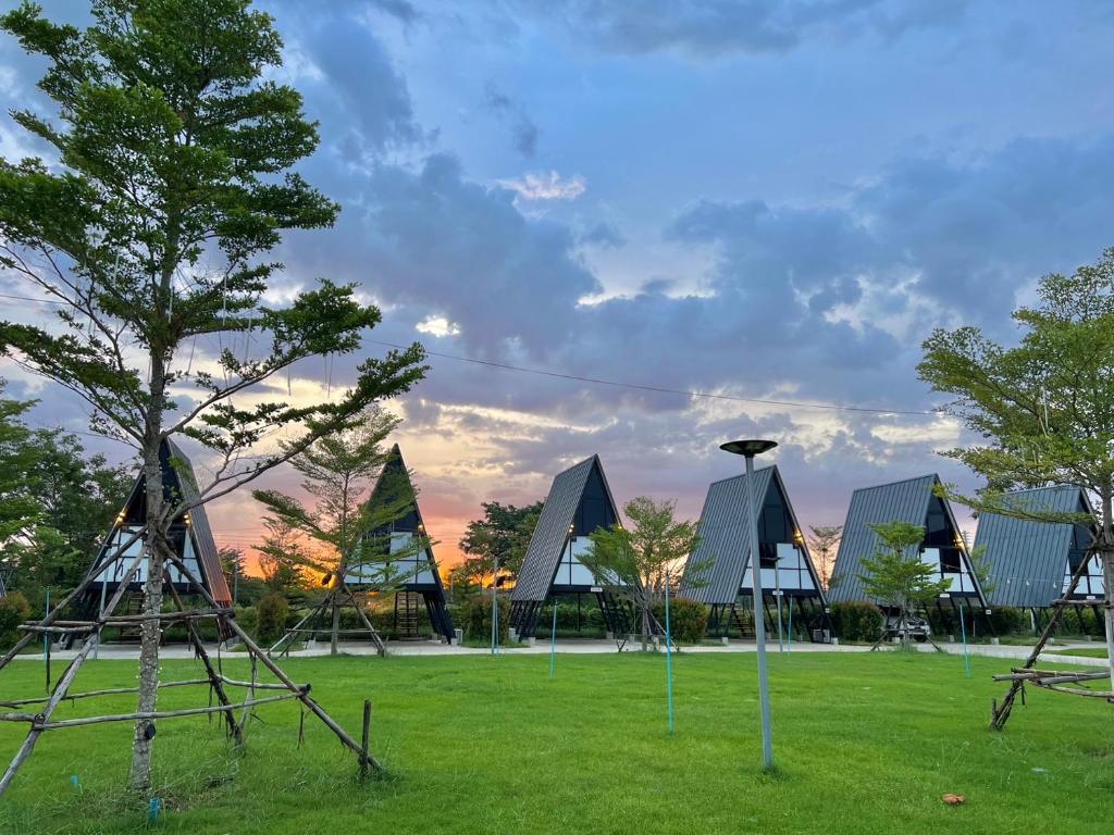 un gruppo di edifici in un campo con un albero di Sean Sawat Resort 2 