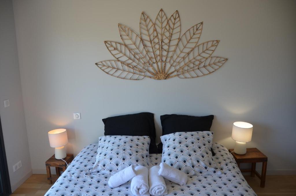 a bedroom with two beds with pillows and a clock on the wall at Le Panorama du Lac in Sévrier
