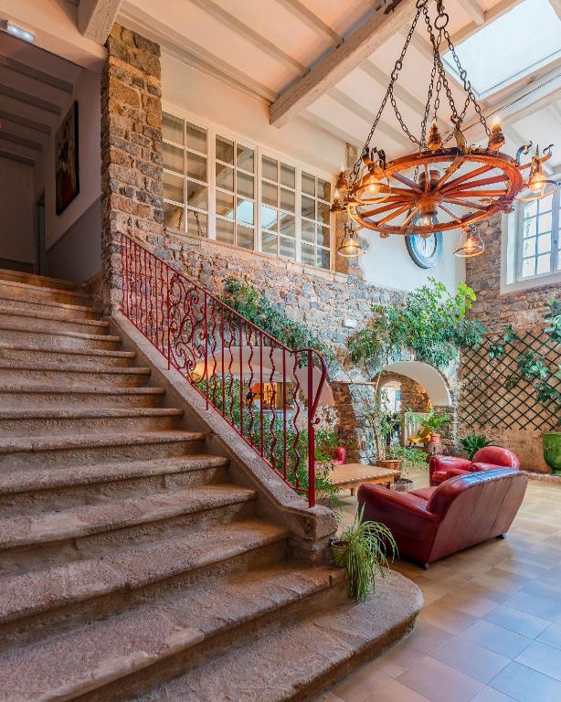 - un escalier en pierre dans une maison dotée d&#39;un lustre dans l&#39;établissement Logis Hôtel Restaurant Le Pradinas, à Anduze