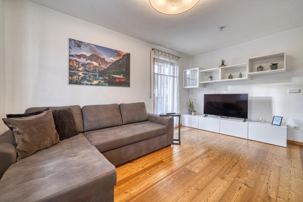 uma sala de estar com um sofá e uma televisão de ecrã plano em FaWa Apartments "Family" em Brunico