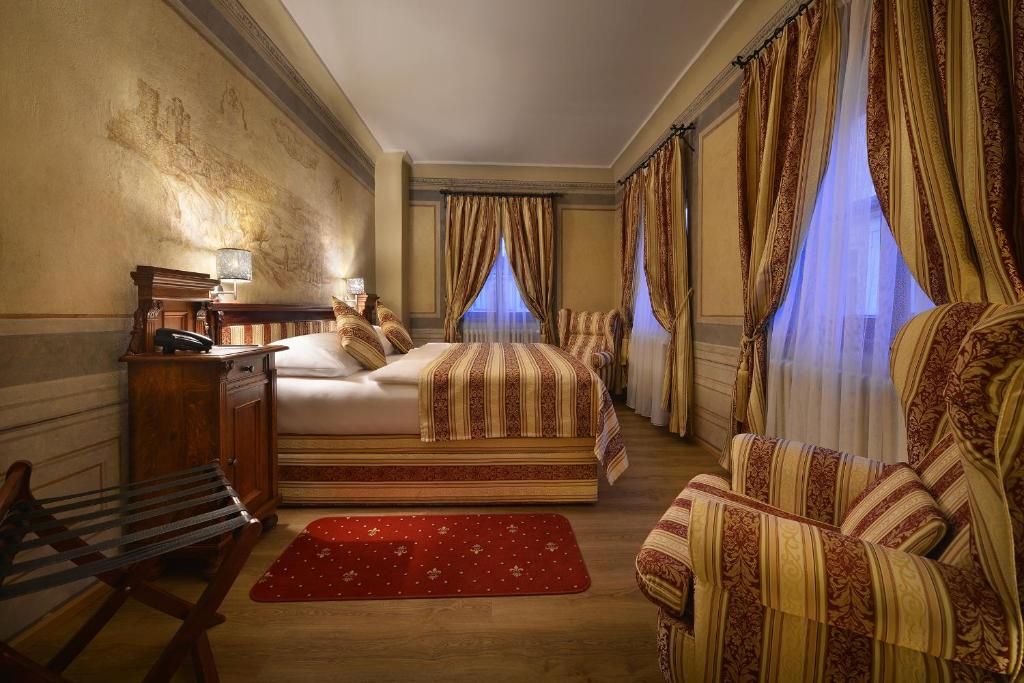 um quarto com uma cama com dois gatos sentados nela em The Charles em Praga